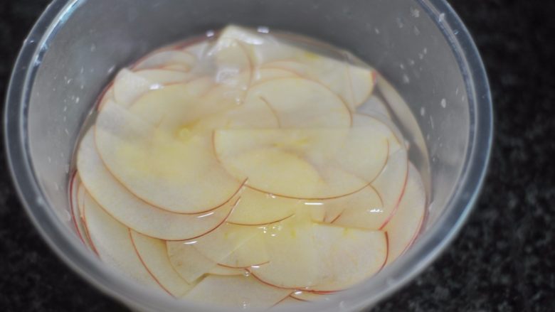 苹果花土司盒,切之前拿盆加一勺盐进去，搅拌融化，边切边将苹果片扔进盆中浸泡，知道将苹果片全部切完就可以了，这样可以防止苹果氧化