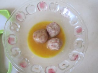 杂蔬冬瓜烧土豆丸,将搓好的土豆丸子放入鸡蛋液中滚一下，让土豆丸均匀的裹上蛋液；