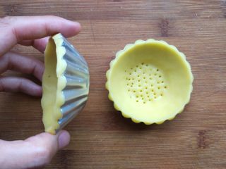 迷你水果挞,擀成3毫米厚，盖在迷你菊花模中。压断边缘多余部分。整理边缘，用叉子或滚孔轮刺出气孔。