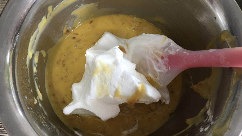 玫瑰花酱戚风蛋糕,取三分之一蛋白霜放入蛋黄中。（混合蛋白时可以开始预热烤箱，温度为150度）利用J型的手法翻拌均匀。