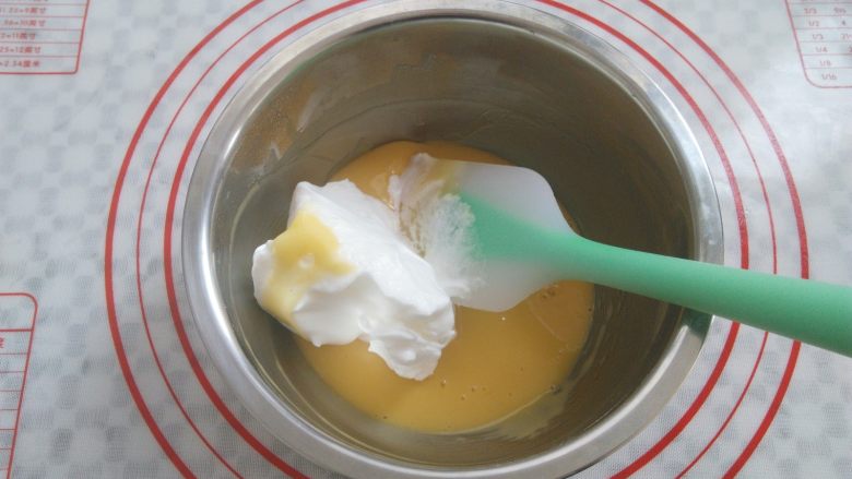 冰淇淋小蛋糕,取三分之一蛋白霜放入蛋黄糊，2-8点钟方向手法翻拌均匀