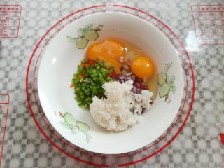 洋葱蔬米饼,把洋葱碎，胡萝卜碎，青椒碎，鸡蛋，米饭放入大碗里
