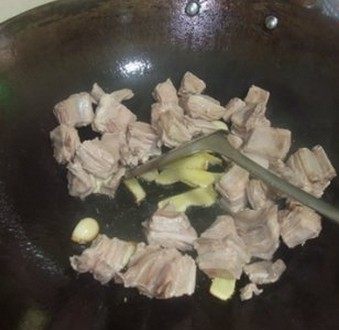 支竹羊腩煲,炒锅放入少许油爆香姜片和蒜子，放入羊腩，不停翻炒至羊腩干水