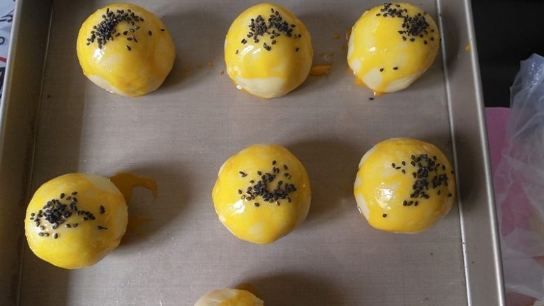 蛋黄酥黄油版,(烤箱预热170度上下火)包好的蛋黄酥 我们在表面刷上蛋黄液在撒上芝麻。