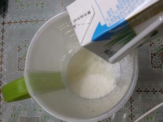 蔓越莓酸奶,大量杯洗净消毒后放入白砂糖和一盒纯牛奶