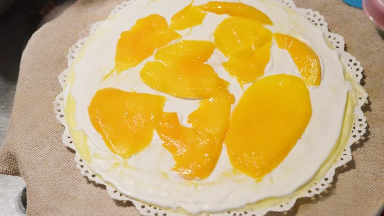 颜值与美味并存的千层蛋糕,摆上水果，想要平整，芒果最好切片，或者切成比较小的芒果块，水果摆放的也要比较平整
