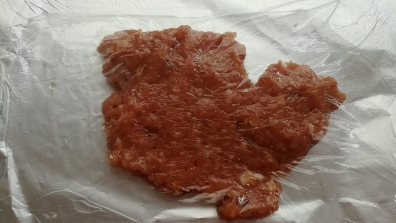 自制猪肉脯,取一张40cm长度的锡纸，在锡纸上抹一层油，放上一半的肉沫，盖一层保鲜膜