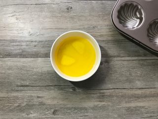 橙香玛德琳,黄油隔水融化。（不必等黄油块全部融化就可以离热水，未融化的小块靠黄油余温来融化）