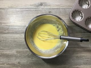 橙香玛德琳,加入事先融化好的黄油，继续之字形搅拌均匀。