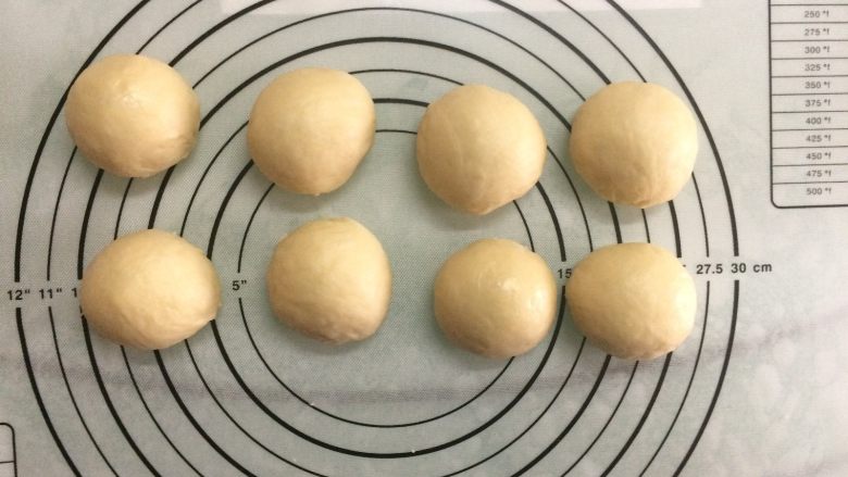 椰蓉面包小卷,将面团取出排气后平均分割成8份，滚圆盖上保鲜膜松弛15分钟。