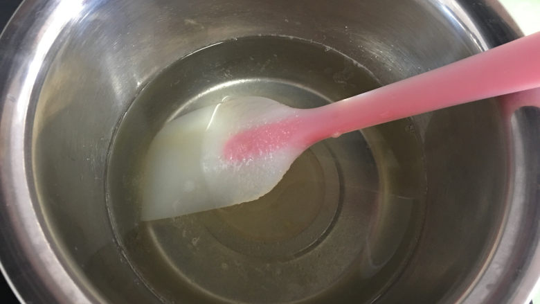 芒果水晶果冻,一边加热一边搅拌，搅拌至糖完全溶解后关火，趁水热的时候倒入溶解好的吉利丁溶液。