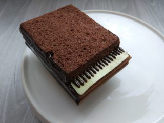可可钢琴蛋糕,将凝固的白巧克力条放在琴键位置，用黑巧克力画出琴键