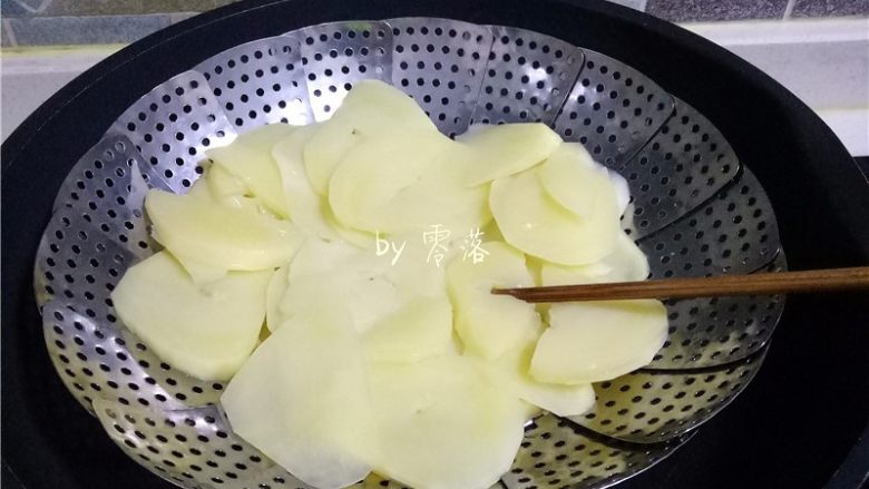 咖喱土豆盖饭,锅里倒入清水烧开，放入蒸片，再放入土豆蒸熟；