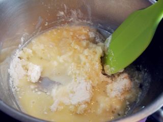  酥皮蘑菇泡芙,关火后，倒入过筛的高筋面粉，用抹刀快速碾拌均匀