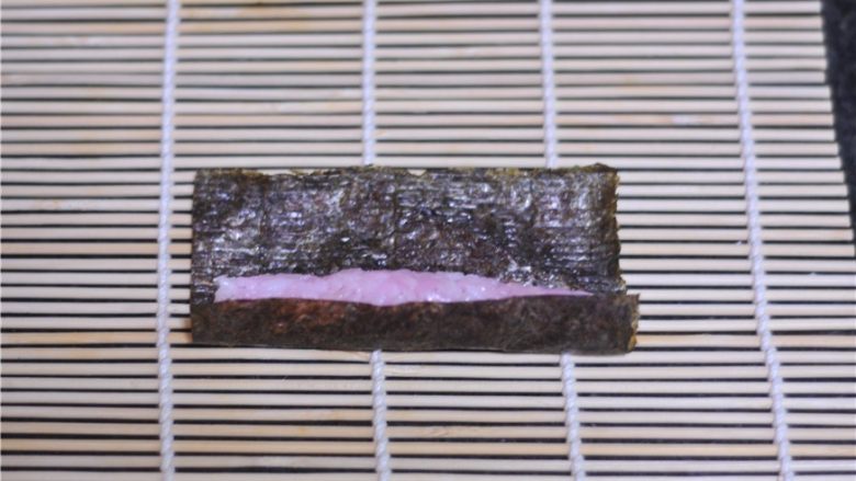 花朵寿司——小朋友最爱哦,搓好的米饭条放在紫菜片的一端，卷起来