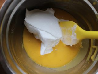 鸡尾酒戚风蛋糕,先取一部分蛋白霜与蛋黄糊混合。切记要用切拌或者翻拌手法