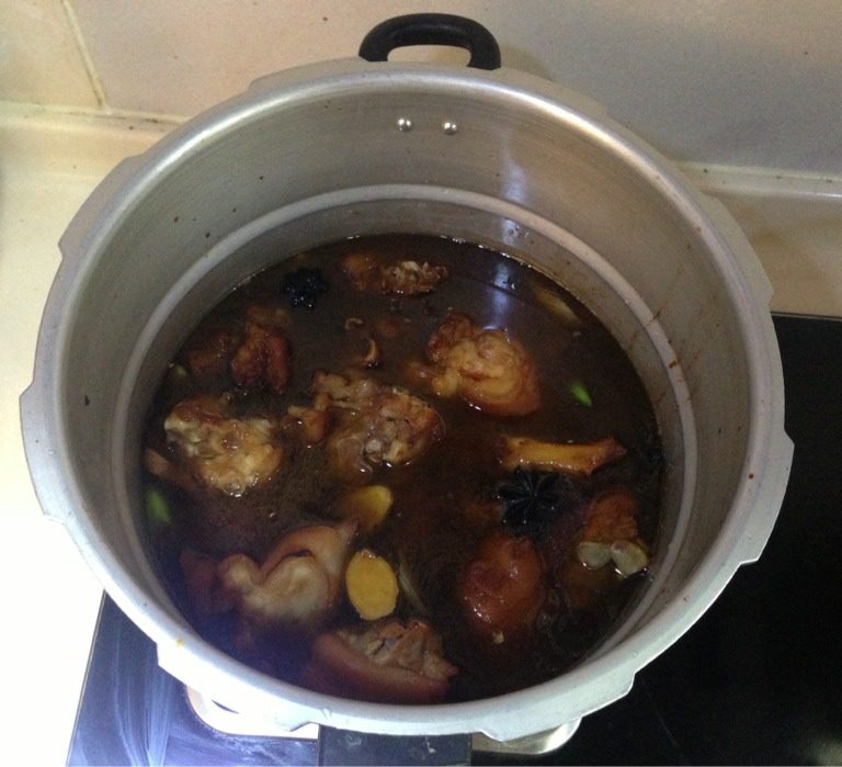 红烧猪脚,均匀上色后，将炒锅里的猪脚及全部辅料放入高压锅里，并倒入适量热开水，放入适量盐，盖盖子压力20分钟