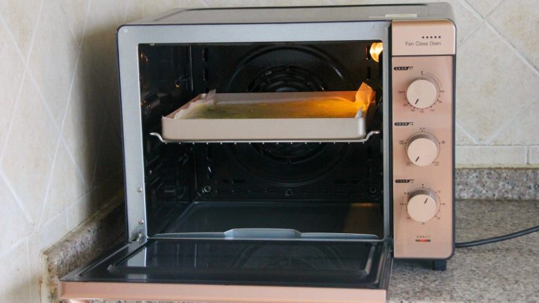 抹茶漩涡蛋糕,14．	把烤盘放到预热好的烤箱内。