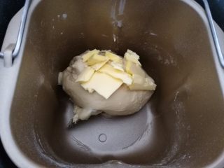 水果鱼面包,2.第一个揉面程序结束后，放入黄油继续揉至薄膜状态。