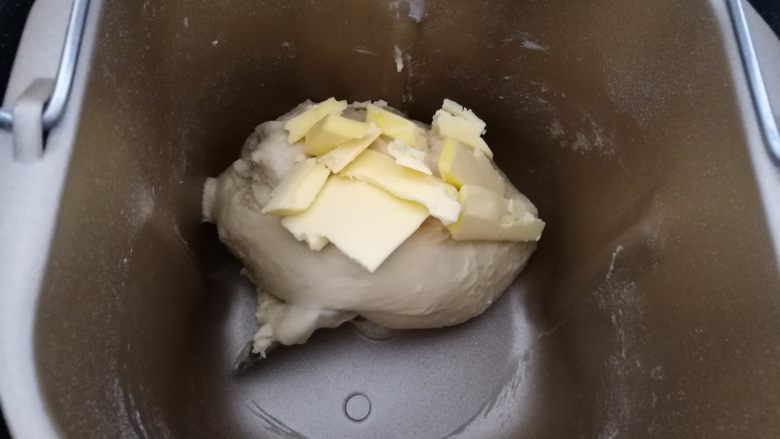 水果鱼面包,2.第一个揉面程序结束后，放入黄油继续揉至薄膜状态。
