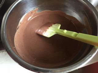 巧克力三重奏慕斯,黑巧克力隔热水融化后，加入到其中的一份奶油糊里，搅拌均匀