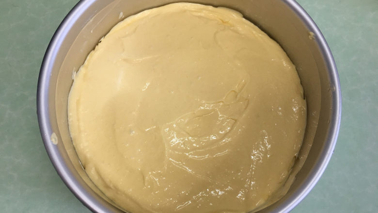 8寸芒果慕斯蛋糕,将芒果慕斯液一半倒入提前准备的模具中抹平。
