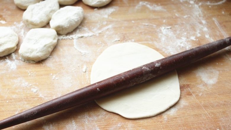 土豆丝卷饼,取一个面剂子，按平，用擀面杖擀大一点。