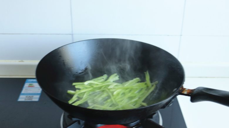 土豆丝卷饼,炒锅放油烧热后，下入青椒丝翻炒10秒钟。