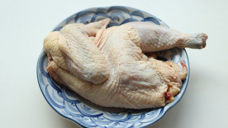 葱油白斩鸡,清洗干净，减去脚尖和鸡屁股，切半只，鸡爪和鸡脖以上部位都不要。