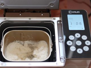 牛奶土司,3.启动面包机揉面功能 揉到面团光滑
