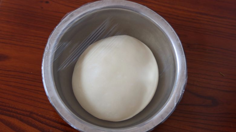 牛奶土司,6.面团放入盆内盖保鲜膜进行第一次发酵 （我这边温度30度左右，放阳台上30分钟左右）