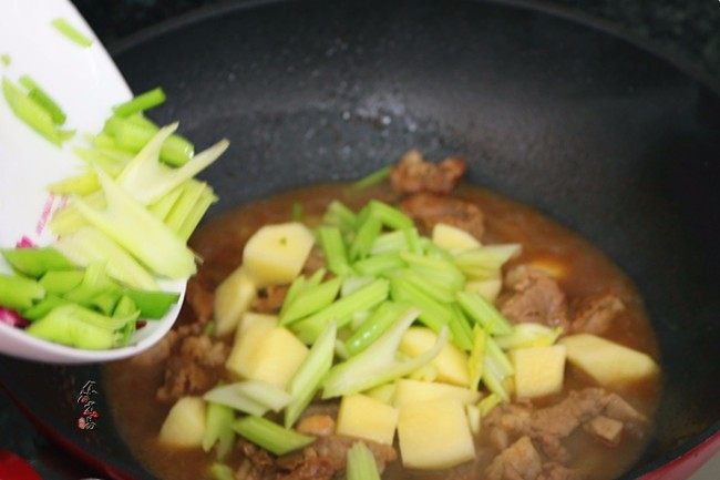 香辣土豆猪骨干锅,倒进芹菜，翻炒均匀，继续遮盖大火焖煮片刻