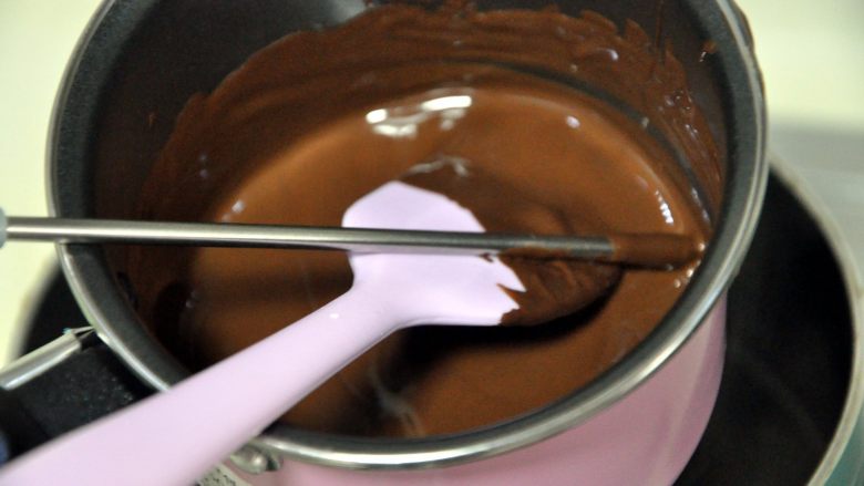 心型调温巧克力,一边加热一边搅拌，将巧克力加热到50-55度之间，这是黑巧克力的溶解温度，注意不要超过55度，巧克力过热会水油分离，结块。