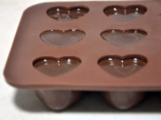 心型调温巧克力,将花嘴剪开一个小口，从模具的底部开始挤，挤好后轻轻震一下模具，震掉气泡。