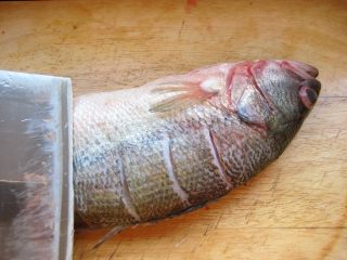 川香麻辣烤鱼：麻辣过瘾的豪华烤鱼,鱼收拾干净，在鱼身上划几刀以便入味。