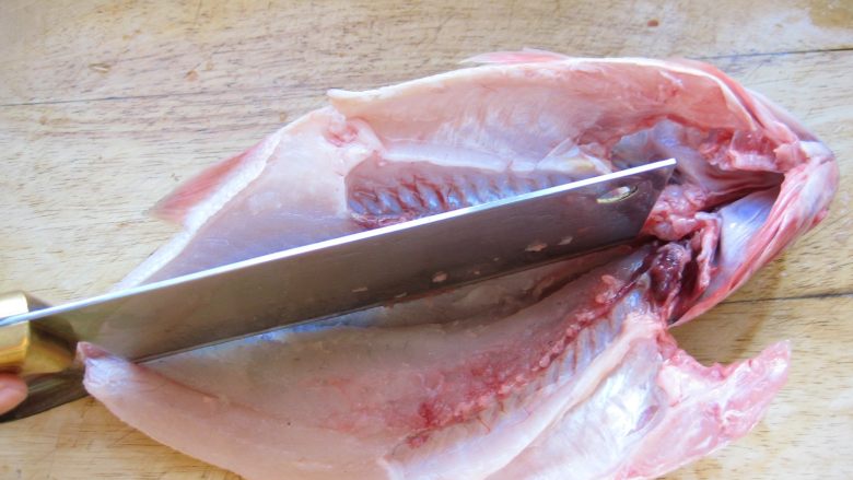 川香麻辣烤鱼：麻辣过瘾的豪华烤鱼,然后沿着鱼腹部的大骨将鱼切成2半，背部相连不要切断。
