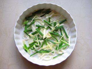 川香麻辣烤鱼：麻辣过瘾的豪华烤鱼,将洋葱丝、香葱段、姜丝均匀的铺在大烤盘中。
