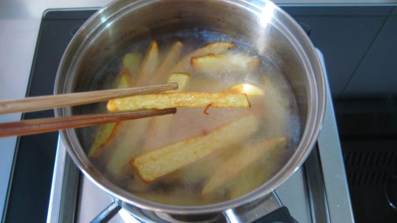 川香麻辣烤鱼：麻辣过瘾的豪华烤鱼,锅中倒油烧热，分别将土豆和莲藕炸制金黄捞出备用。
