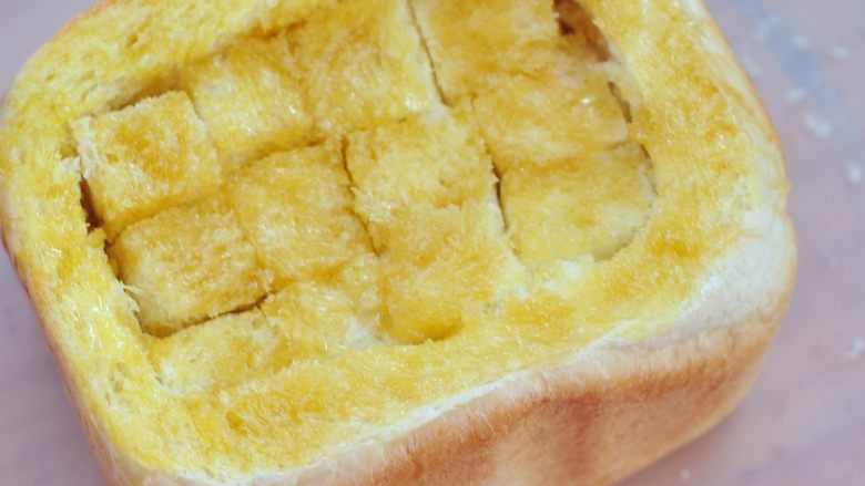 蜂蜜厚多士,把面包丁码好一层，刷一层黄油蜂蜜液，直到码好最后一层，面包边缘也要涂抹上液体。