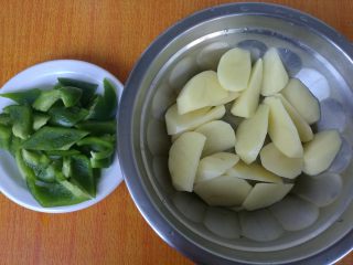 地三鲜,青椒洗净切成块，土豆去皮洗净切成块。