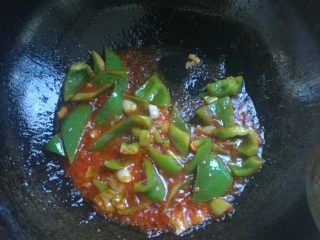 地三鲜,放入2大勺番茄酱炒出亮色，下入青椒块。