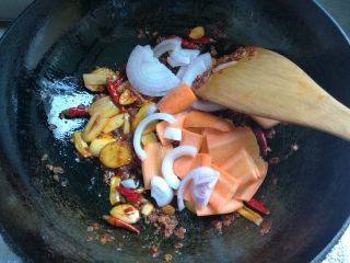 鲜香麻辣章鱼足,放入洋葱红萝卜，煸炒均匀。
