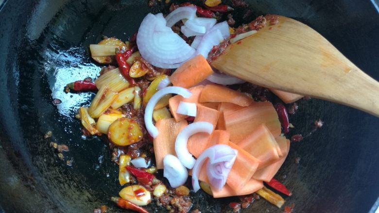 鲜香麻辣章鱼足,放入洋葱红萝卜，煸炒均匀。