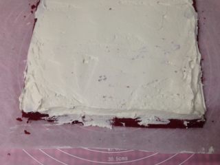 红丝绒蛋糕卷,
抹上淡奶油，起始端抹厚一点，末端涂薄薄一层就行，并且留3cm不涂奶油，以免卷的时候奶油漏出