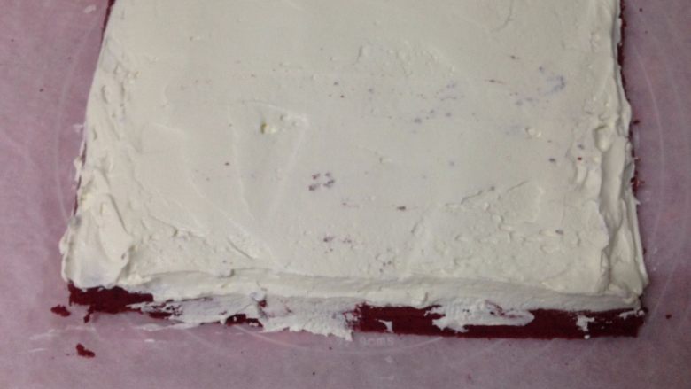 红丝绒蛋糕卷,
抹上淡奶油，起始端抹厚一点，末端涂薄薄一层就行，并且留3cm不涂奶油，以免卷的时候奶油漏出