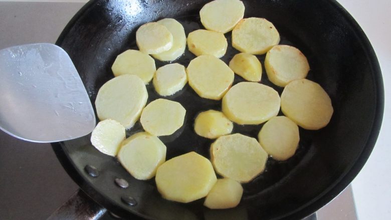 豆豉辣炒茄子土豆片,待一面煎的微微发黄时翻一面继续煎， 煎到双面金黄后盛出；
