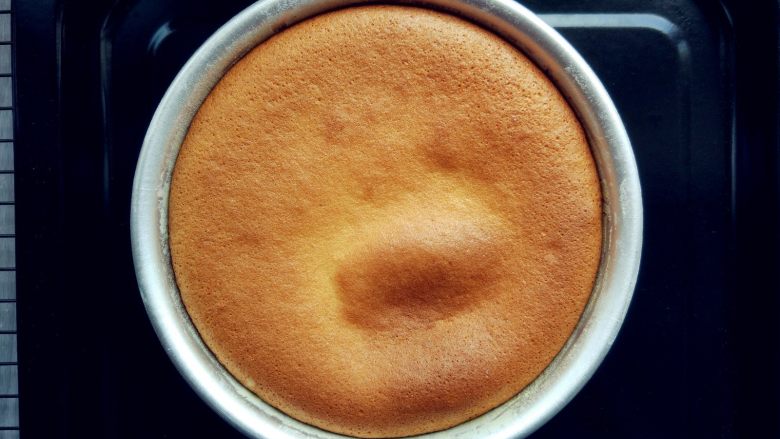 蜂蜜流心凹蛋糕,出炉后，冷却。刚出炉是中间是凸起的，经过自然冷却排气后，中心会凹陷下去，可以看到蛋糕体上色均匀，说明炉内加热温度均匀