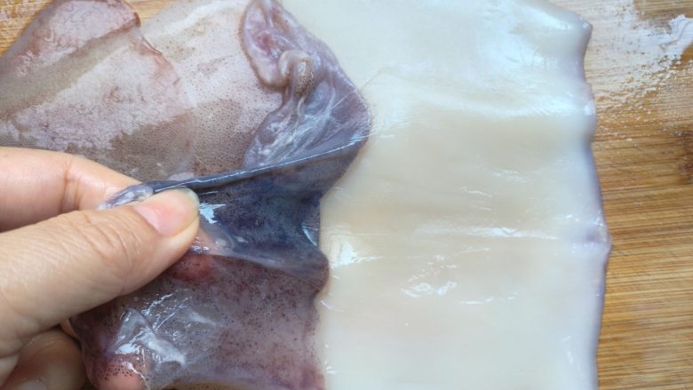 双椒爆鱿鱼,揭去鱿鱼背部的一层保护膜，这个膜有一定的毒性，还会影响菜品的品质，所以必须去除。