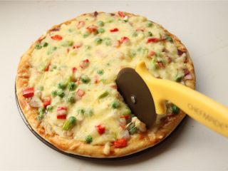 培根田园披萨,烤好的披萨用披萨轮刀切块食用，一定不能直接用刀子切，不然盘子就切坏了。