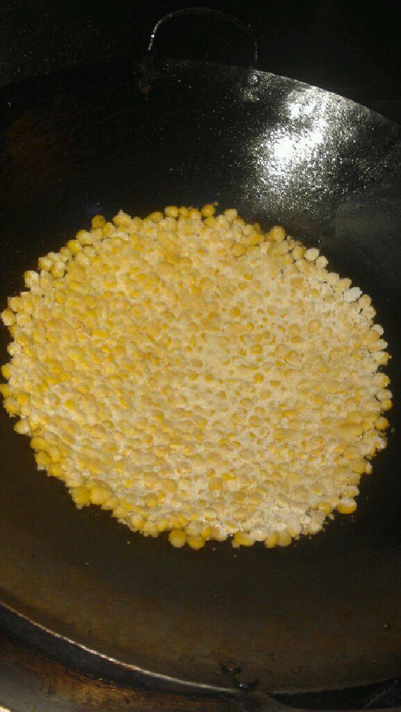 玉米烙,把玉米倒进锅里用手搞平，用手压紧。